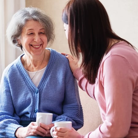 elderly woman talking to carer and smiling