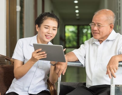 nurse-showing-care-home-resident-software-on-a-tablet