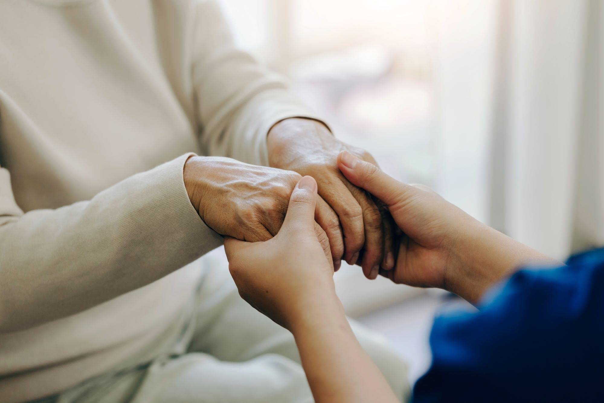 Carer holding hands with resident