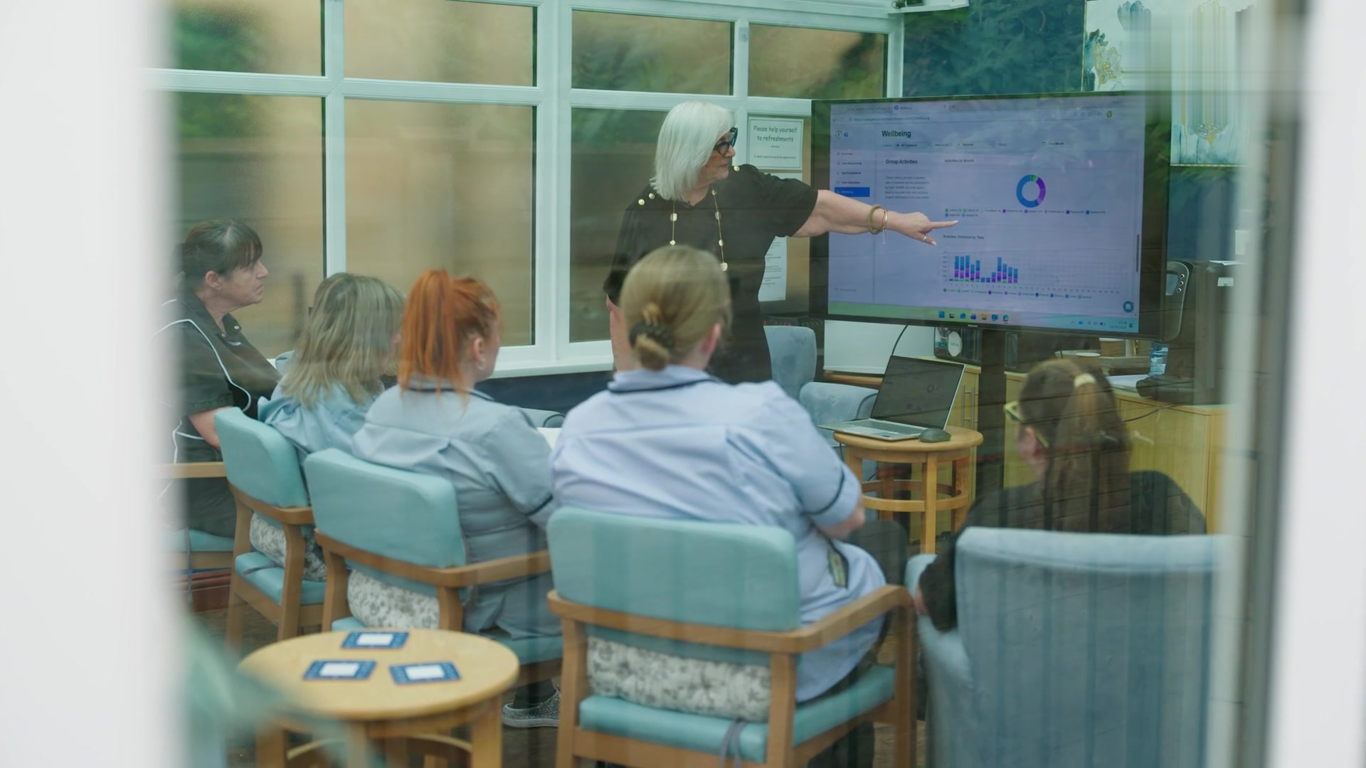 Marina leads staff training session at Beechy Knoll care home with PCS dashboard on big screen