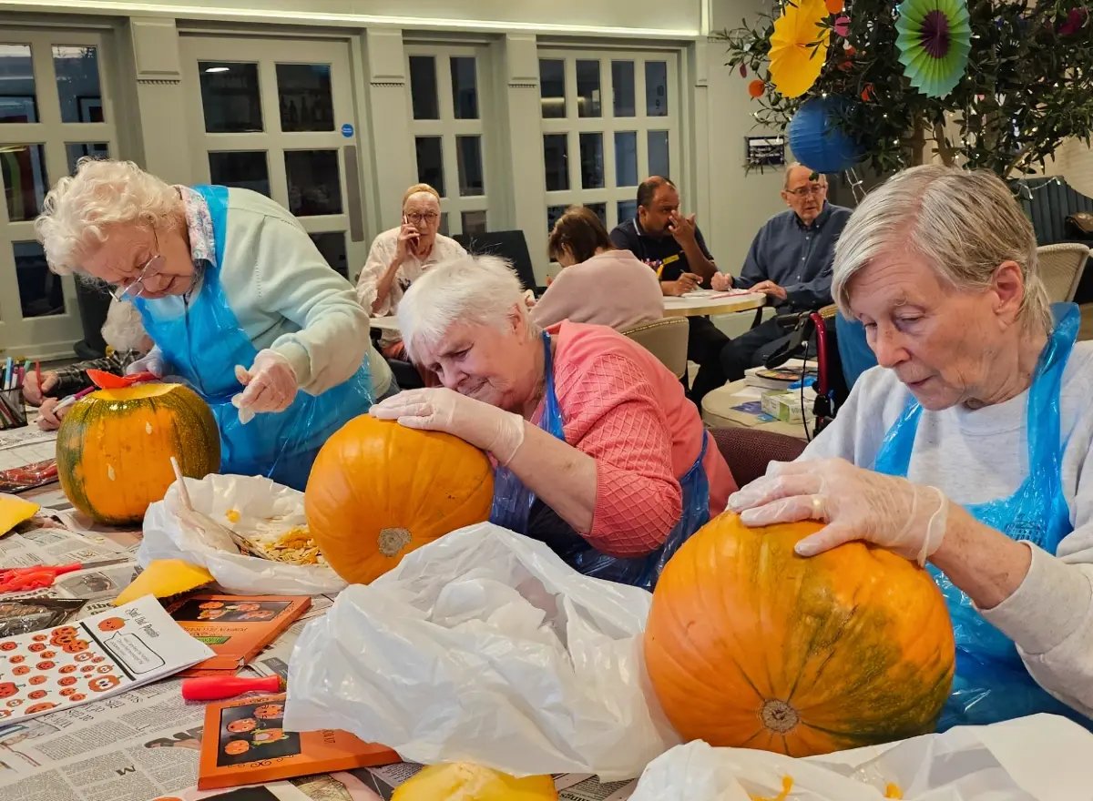 Residents participate in a pumpkin carving activity