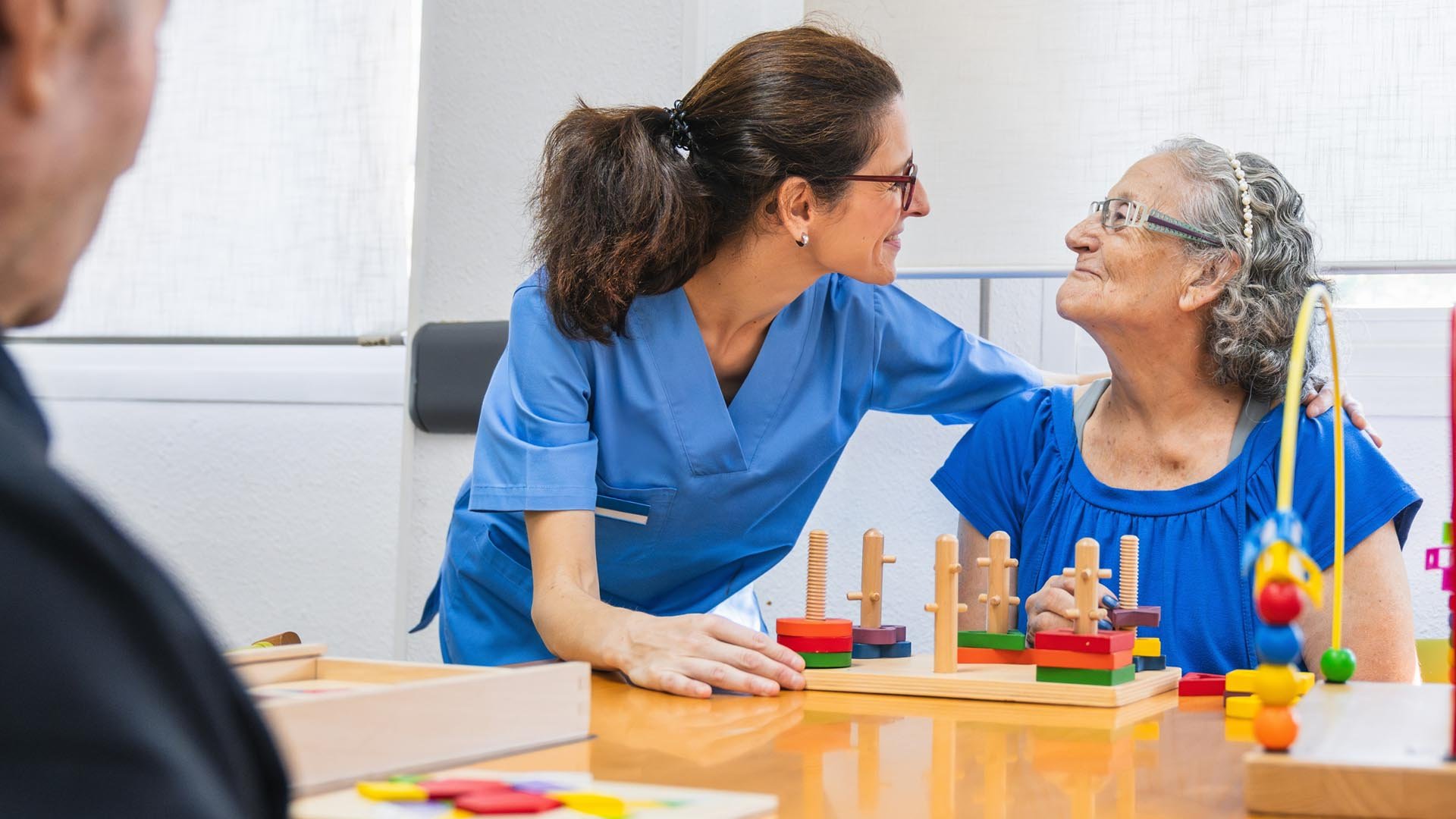 Carer and resident smile together during an activity session