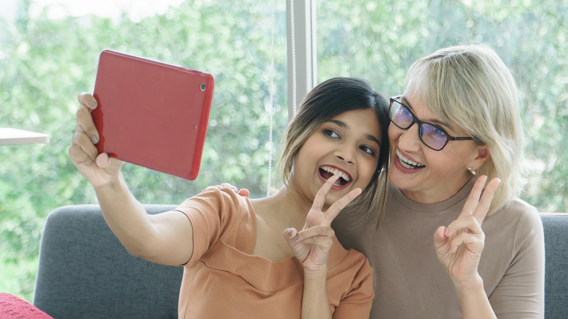 Granddaughter and grandmother take a selfie together with peace fingers