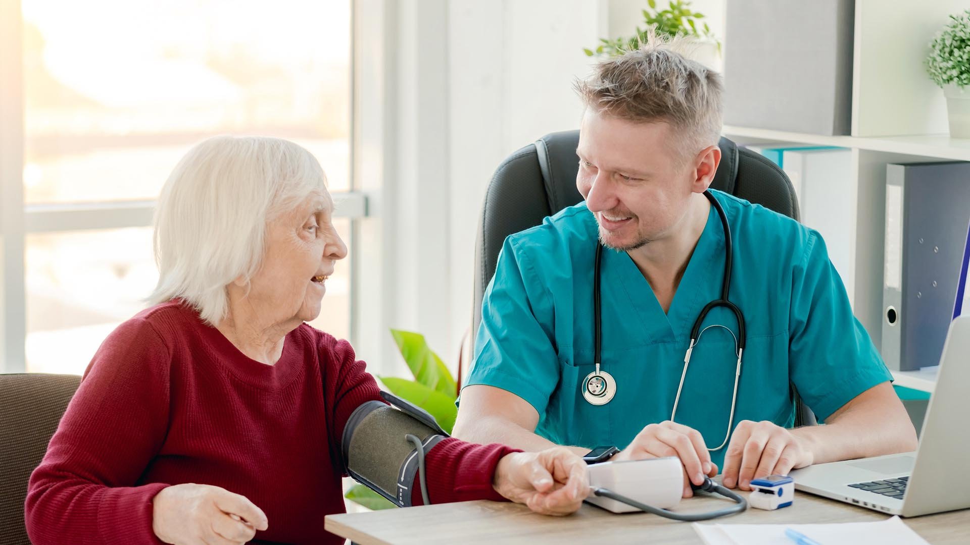 Doctor take the blood pressure of a care home resident