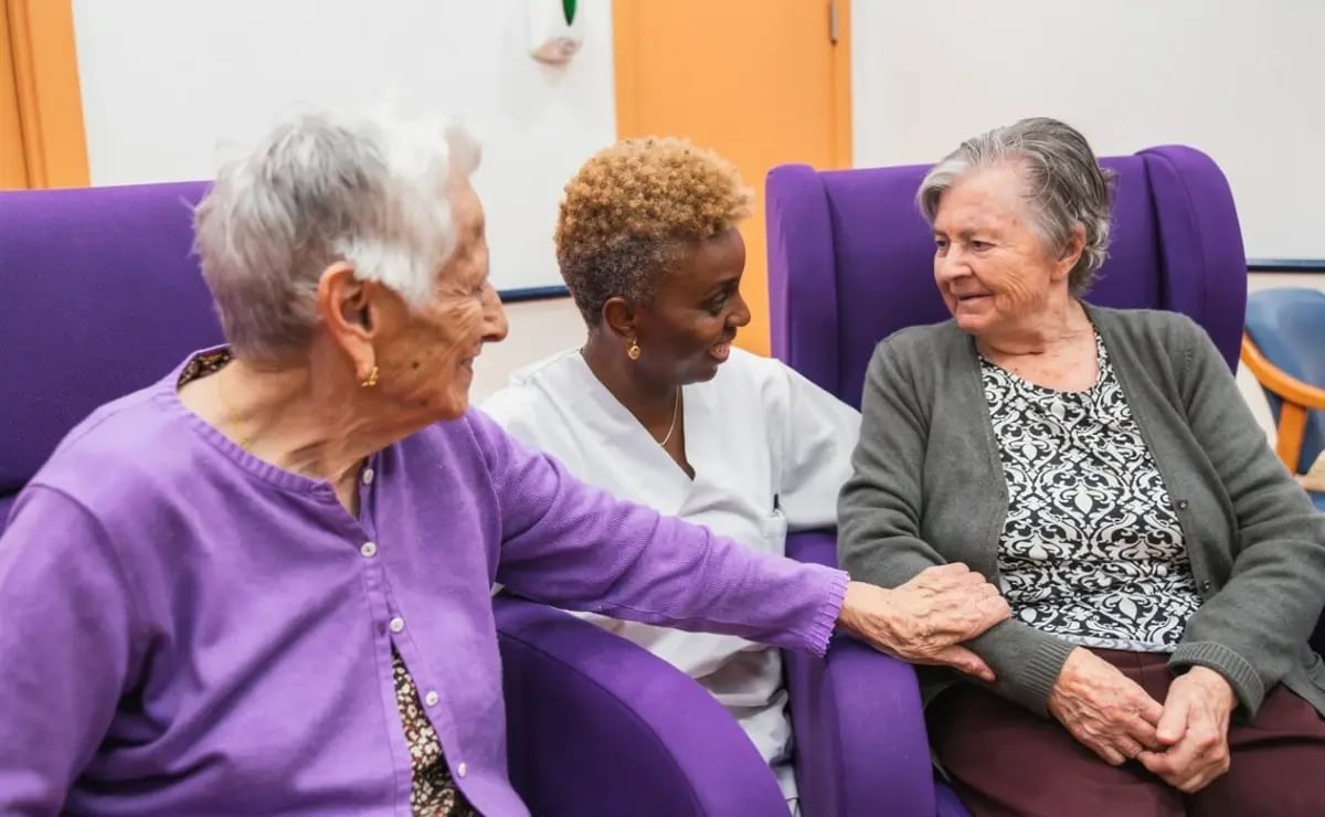 Carer chats with two residents