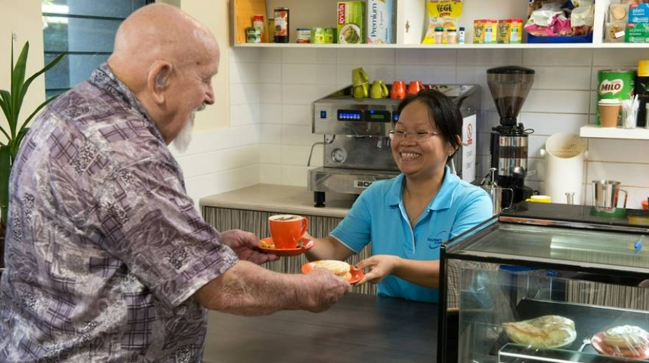 Southern cross woman giving care home resident coffee and a snack