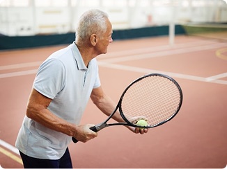 An older man playing tennis.