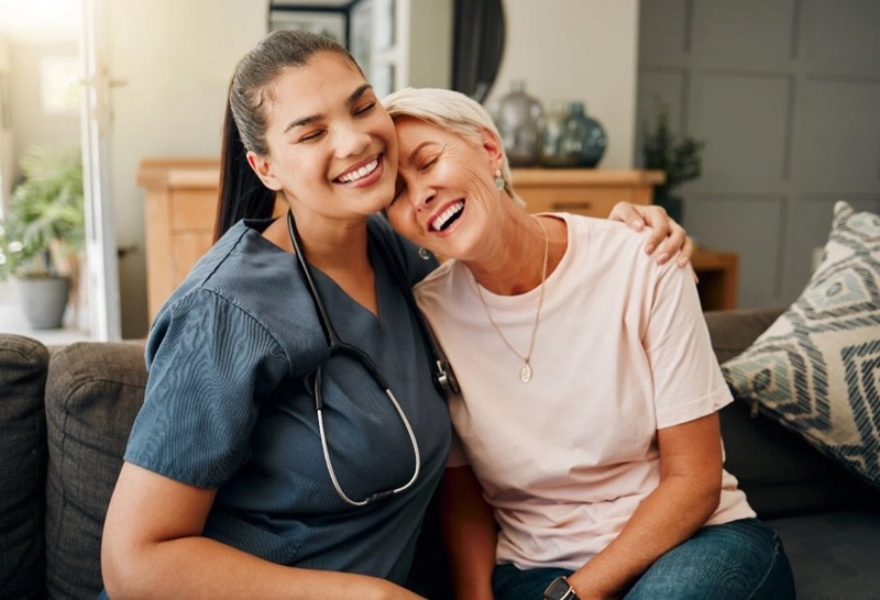 A care team member and a resident laughing together.